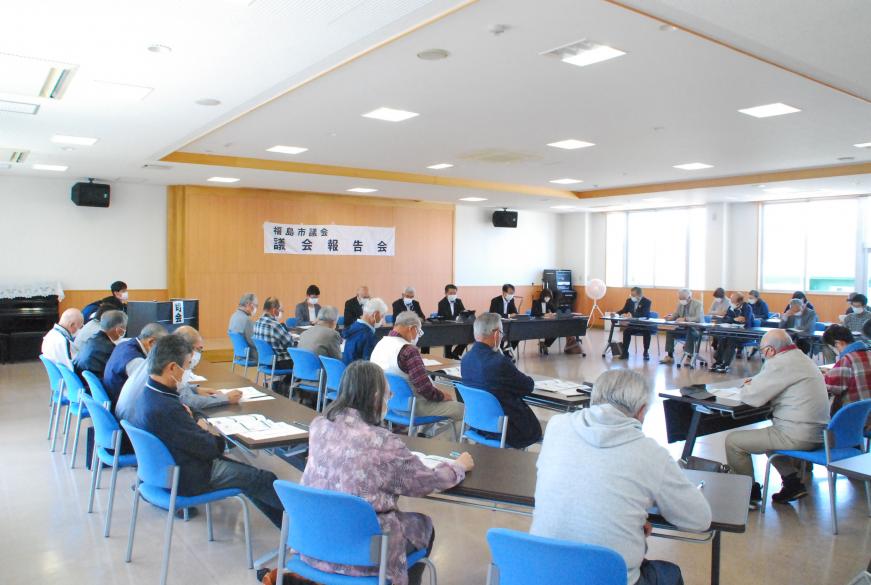 設置された座席に座り資料見ながら参加者たちが話を聞いている様子の写真