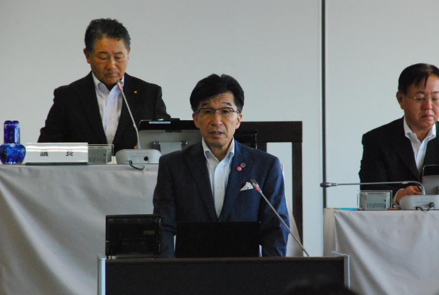 壇上に上がりまっすぐ前を見て話をする市長を撮影した写真