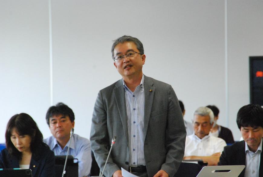 首をかしげながら話をする川又康彦議員を撮影した写真