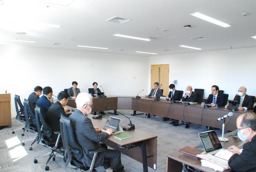 ロの字型に設置されたテーブルの席に関係者の方々が座り調査特別委員会が行われている写真