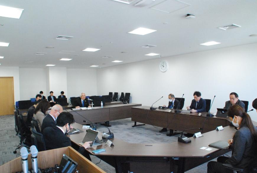 ロの字型の会議テーブルの席や後方席に関係者らが座っており、経済民生常任委員会を行っている写真