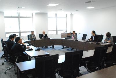 ロの字型に設置した机に委員が座り会議が行われている様子の写真