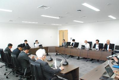 ロの字型に設置した机に委員が座り会議が行われている様子の写真