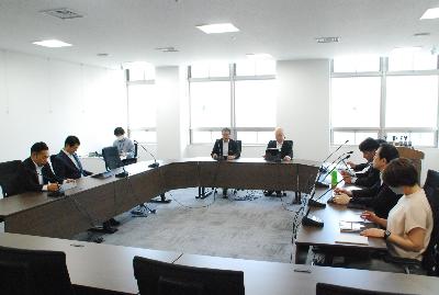 ロの字型に設置した机に委員が座り会議が行われている様子の写真