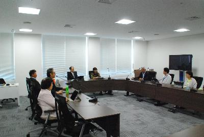 ロの字型に設置した机に委員が座り会議が行われている様子の写真
