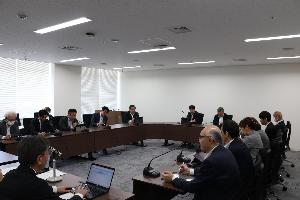 議員13名がタブレットを見ながら協議している写真
