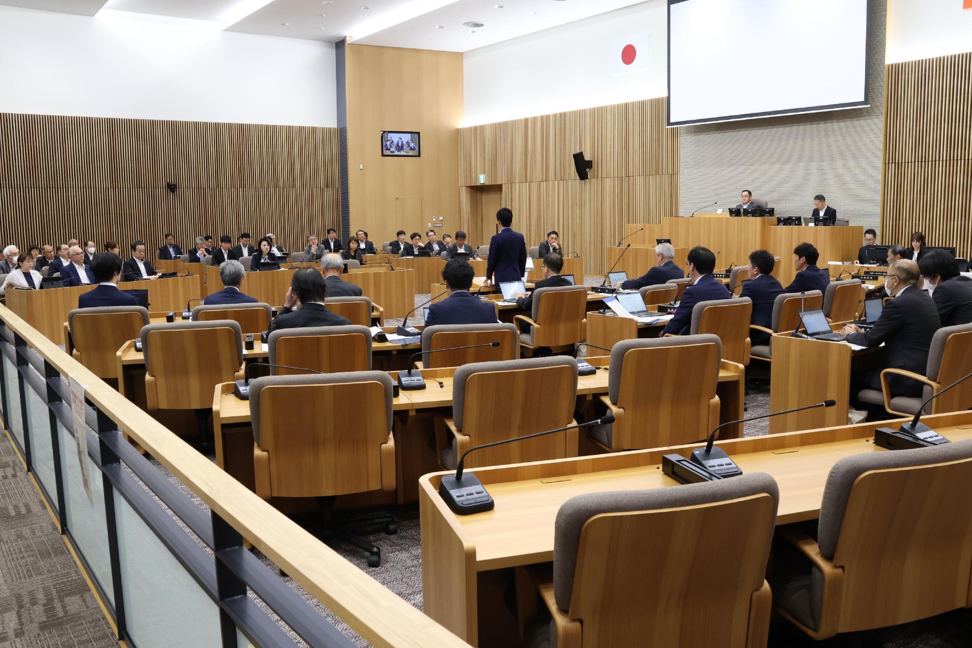 議場で議員全員が市長から説明を受けている写真