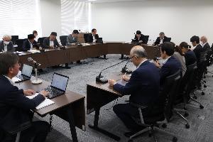 議員13名がタブレットを見ながら協議している写真