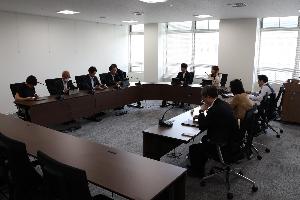委員9名がタブレットを見ながら協議している写真