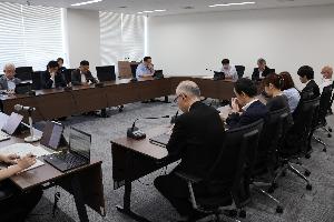 議員12名がタブレットを見ながら協議している写真