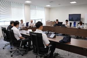委員8名がタブレットを見ながら協議している画像