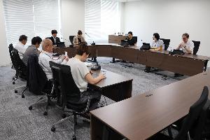 委員9名が協議をしている写真