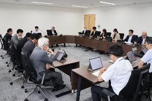 議員13名がタブレット端末見ながら協議している写真
