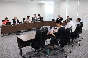 委員9名が当局から説明を受けている写真