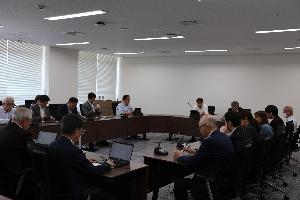 議員13名がコの字型のテーブルに座り、タブレット端末を見ながら協議している写真