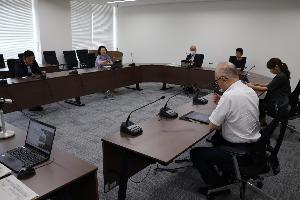 議員6名がコの字型の椅子に座り、タブレット端末を見ながら協議しているところ