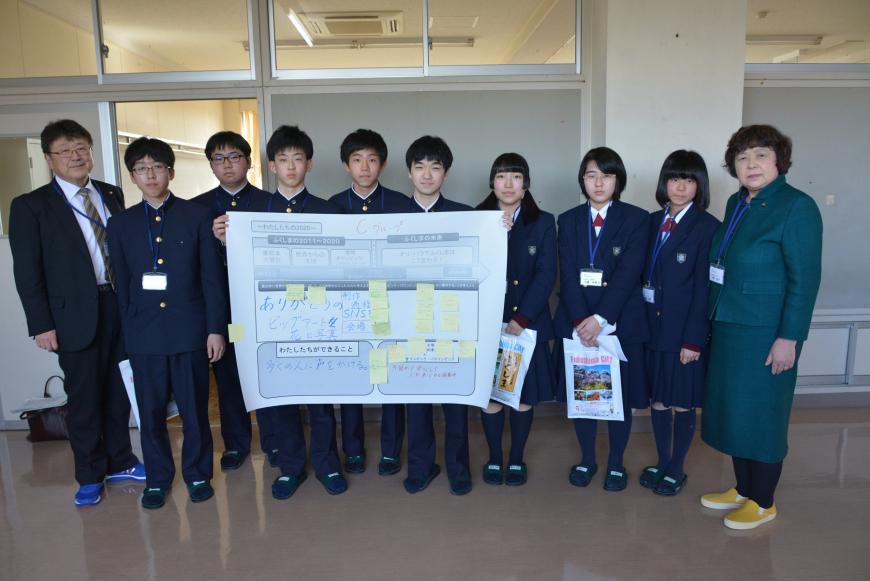 横一列に並んだ参加学生の両サイドに議員の方が立ち、話し合ってまとめ記載された模造紙を中央の男子学生が持ち記念撮影している写真