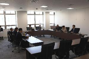 ロの字型に並べられた机に8人ほどが座り、それぞれタブレットの画面を見ている写真