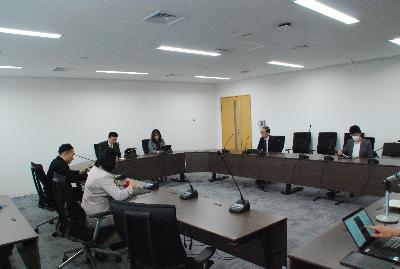 ロの字型に設置した机に委員が座り会議が行われている様子の写真