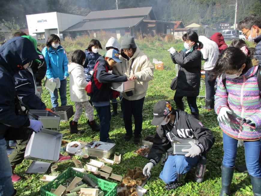 準備された材料の中から好きなものを選び缶に入れているたくさんの参加者の写真