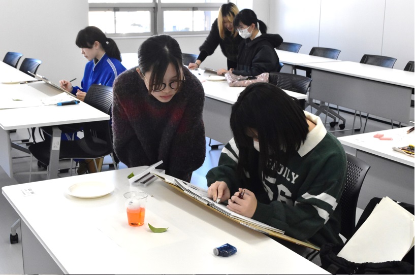 大学生からデッサン指導を受ける様子