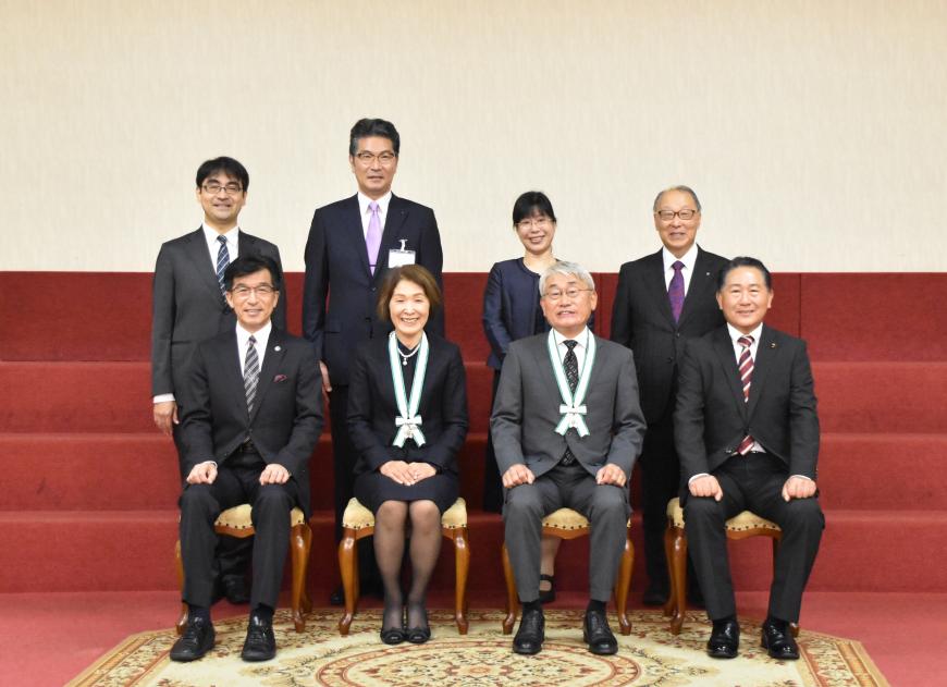 表彰を受けた佐藤 玲子 様、齋藤 吉成 様がメダルを首から下げ、市長と関係者の方々と笑顔で写っている記念写真