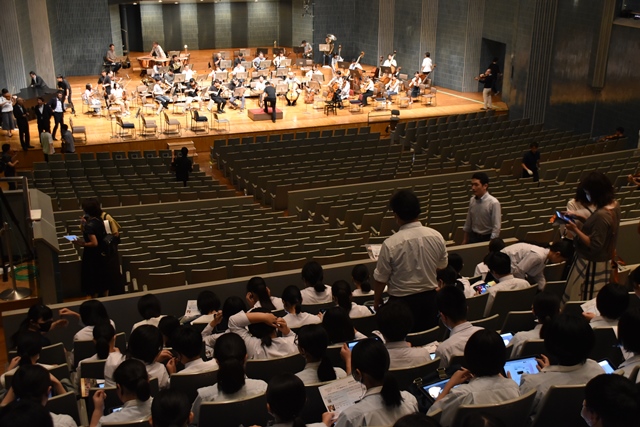 ステージ上ではNHK交響楽団のリハーサルが行われており、客席に生徒の皆さんが座って見学している様子を会場の後方より写した写真