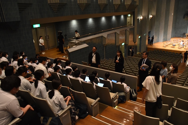 客席に座り見学している生徒の皆さんが、N響指揮研究員の湯川紘惠氏の話を注目して聞いている様子の写真