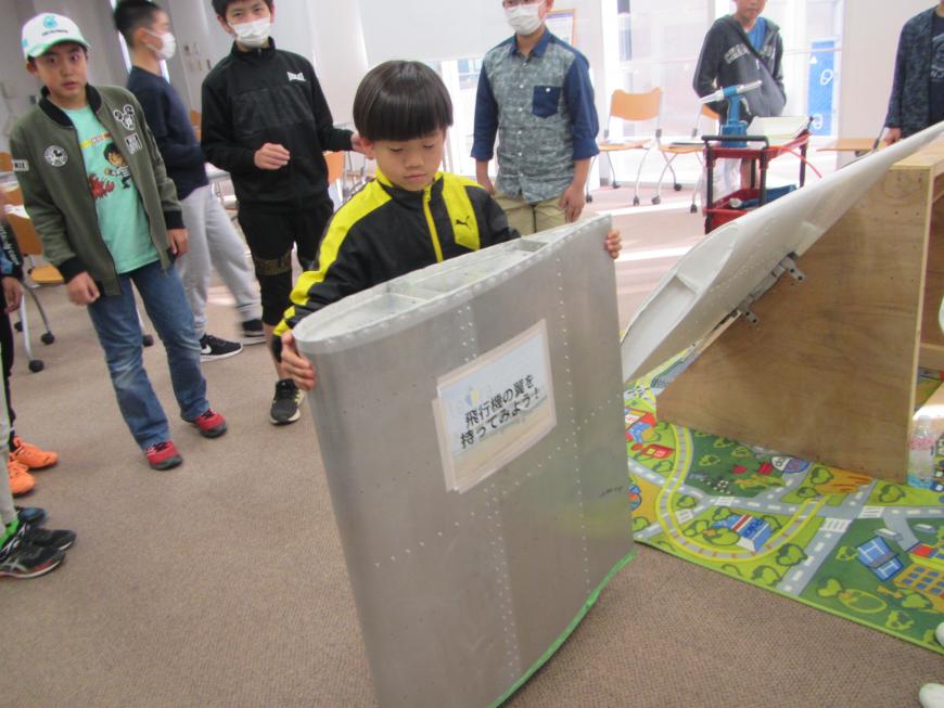 参加者の男の子がシルバーの大きな翼を持っている写真