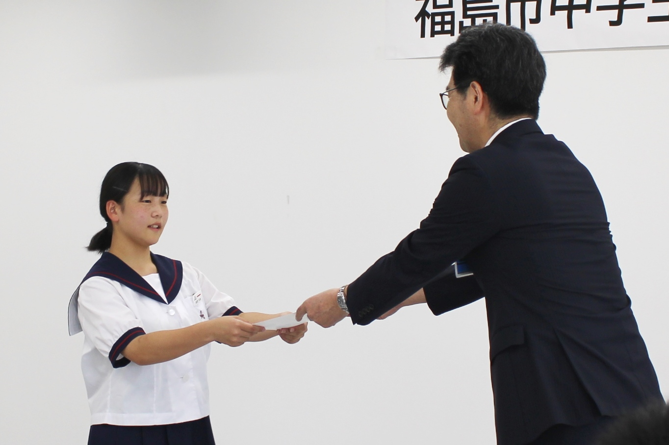 教育長から認証状をもらう中学生
