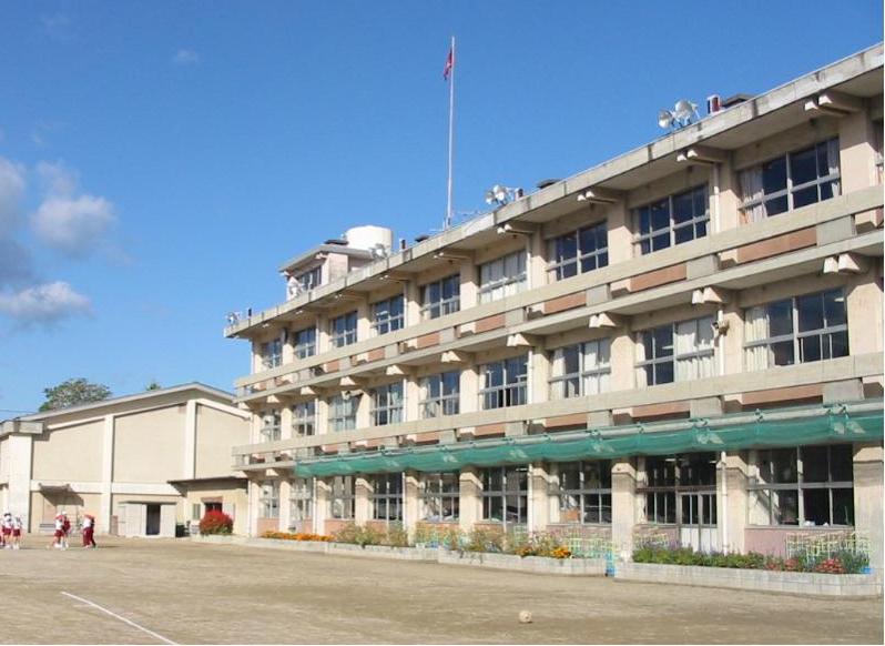 グラウンドに面して3階建ての校舎があり、その左隣に体育館がある福島第二小学校の外観写真