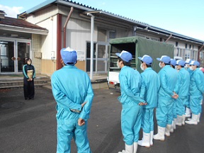 先生の前に横一列に並んで話を聞いている福島明成高等学校の生徒の皆さんを後ろから撮影した写真