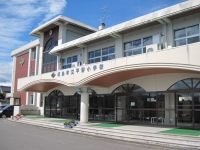 2階建ての校舎の入り口に連続したアーチ型のデザインの雨よけがある平野小学校の外観写真