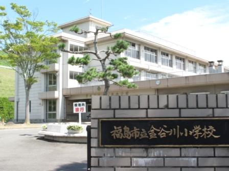 「福島市立金谷川小学校」と書かれた黒い表札がついた門の奥に3階建ての校舎が建っている金谷川小学校の外観写真