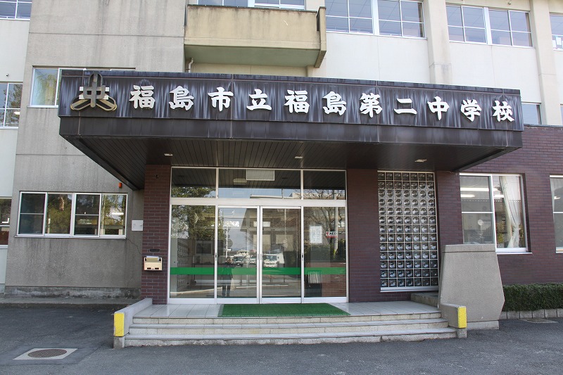 玄関上部に校章と「福島市立福島第二中学校」と表記された福島第二中学校の玄関前の写真