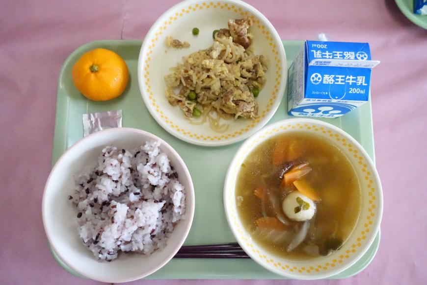 若草色のトレーの上に、紫黒ごはん、だまこ汁、油麩のたまごとじ、パックの牛乳、みかんが乗っている写真