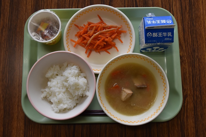 若草色のトレーの上に、ごはん、あぶくま汁、いかにんじん、カップに入った納豆、パックの牛乳がのっている写真