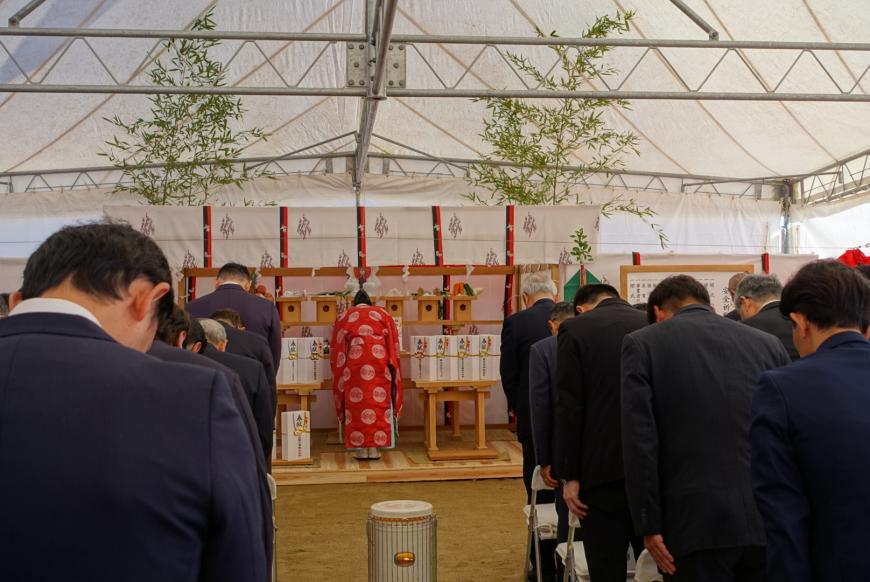 安全祈願祭の祭壇に向かい神主や関係各社がお辞儀をしている様子を後方から写した写真