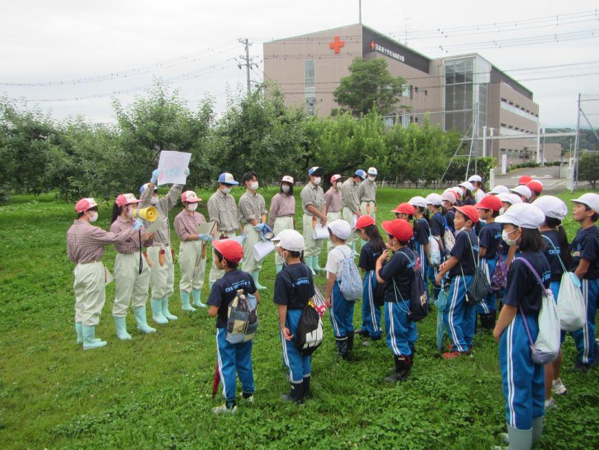 横3列ほどに並んだ大森小学校の児童達の前で福島明成高校の生徒の皆さんが横一列に並び説明をしている写真