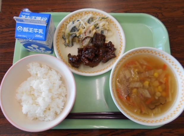 お盆にごはん、にしんの甘露煮、ひき菜炒り、八杯汁、牛乳がのった給食の写真