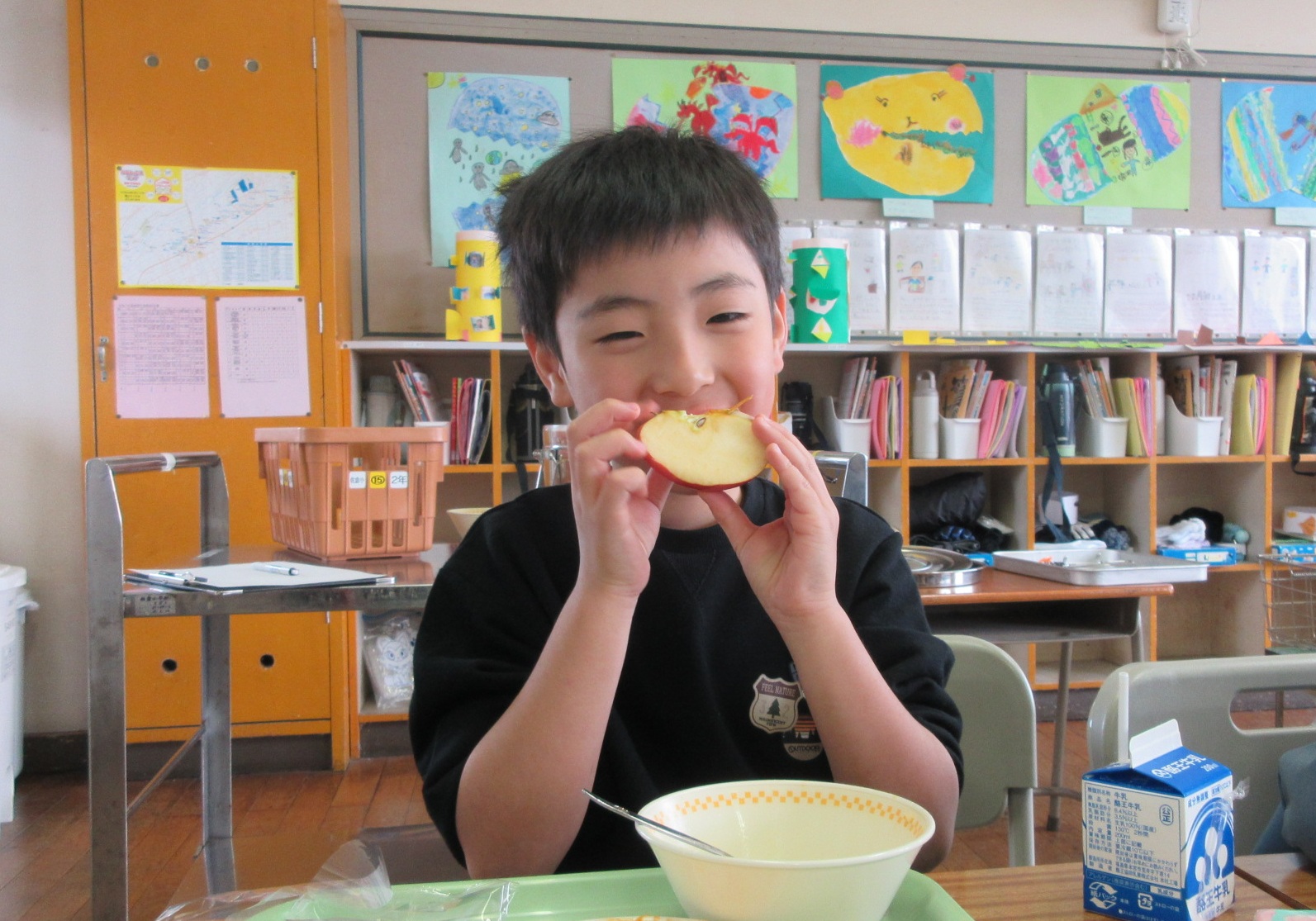 給食で出たりんごを食べる男の子の写真