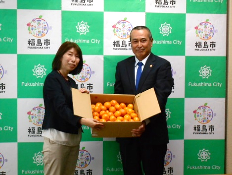 JA熊本宇城柑橘部様からみかんを受け取る教育部長の写真