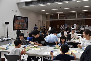 席に着いた参加者たちが、給食を食べている様子の写真