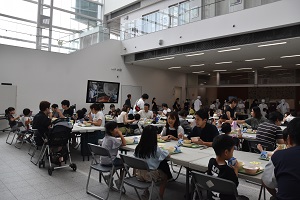 参加者たちが給食を食べている会場全体の写真