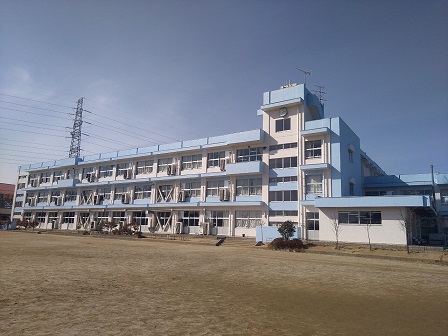 外壁が白と水色で塗り分けられた、3階建ての清水小学校南校舎の外観写真