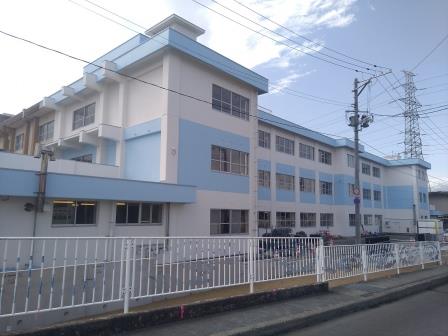 外壁が白と水色で塗り分けられた清水小学校3階建ての北校舎の外観写真