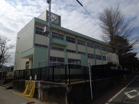 外壁がベージュと薄い緑色で塗り分けられた、杉妻小学校北校舎の外観写真