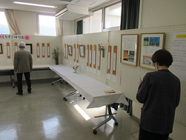 室内に展示されている俳句の作品を来場者が見学している写真