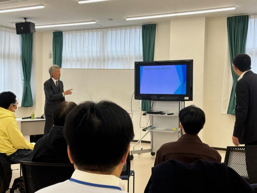 正面のモニターを指さしながら話をしている山下 訓史氏の写真