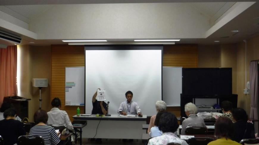 正面の机に男女が並んで座り、講座に参加している人達の後方から写した写真